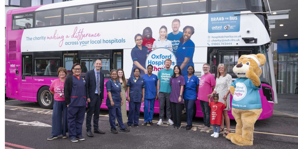 Photo of the Oxford Hospitals Charity branded bus in front of the John Radcliffe Hospital